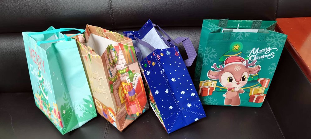 Assorted custom Christmas laminated bags — multiple styles including teal reindeer, blue snowflake, and warm-tone holiday designs from Lion Pack